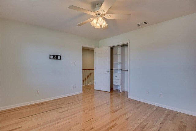 unfurnished bedroom featuring visible vents, baseboards, ceiling fan, light wood-style floors, and a closet