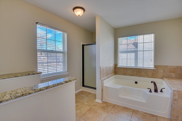 full bath featuring a stall shower, tile patterned flooring, baseboards, and a bath