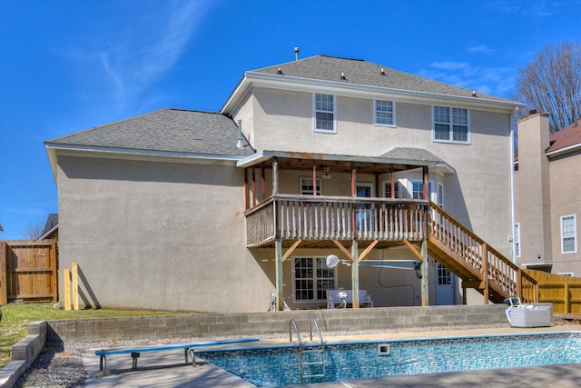 rear view of property with fence, stairs, roof with shingles, a fenced in pool, and stucco siding