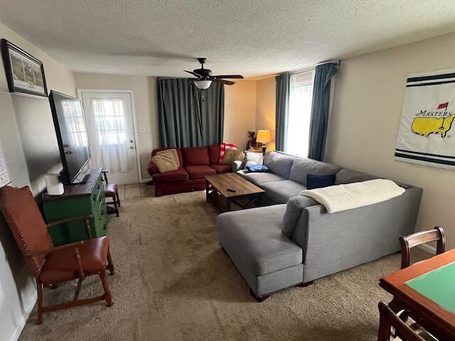 carpeted living room featuring a textured ceiling and ceiling fan