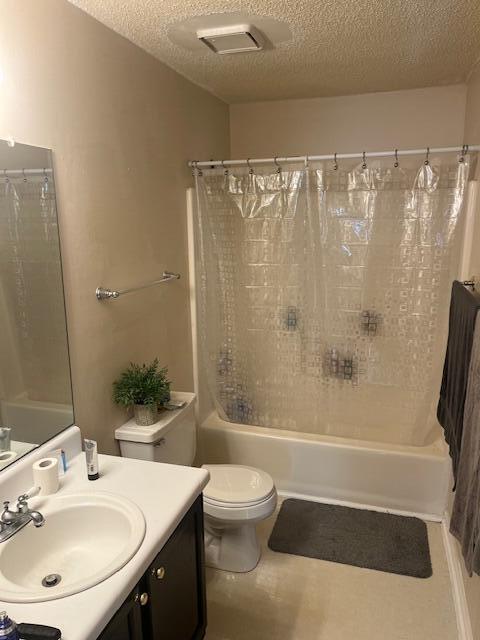 full bath featuring shower / bathtub combination with curtain, visible vents, toilet, a textured ceiling, and vanity