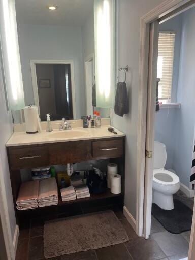 bathroom with tile patterned flooring, toilet, vanity, and baseboards