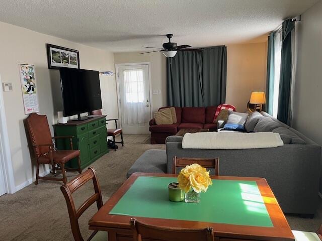 living room featuring carpet floors, a textured ceiling, and ceiling fan