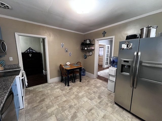 kitchen with visible vents, stone finish floor, appliances with stainless steel finishes, crown molding, and baseboards