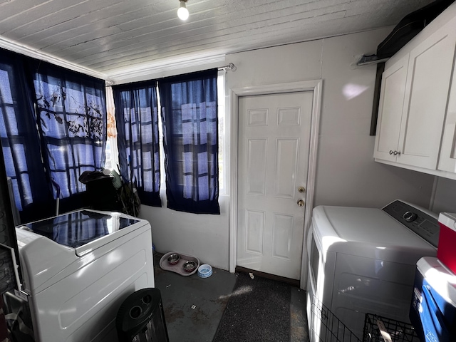 laundry room with cabinet space, wooden ceiling, and washing machine and clothes dryer