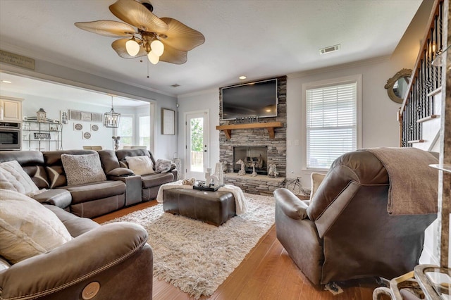 living room featuring a fireplace, hardwood / wood-style flooring, and crown molding