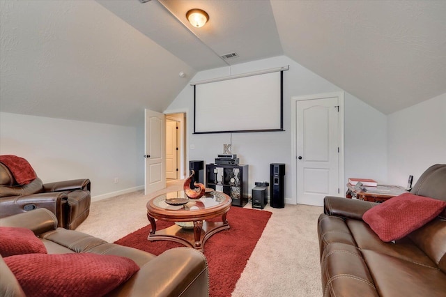 cinema room featuring a textured ceiling, lofted ceiling, and light carpet