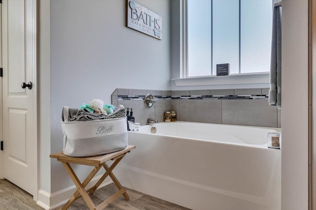 bathroom featuring wood-type flooring and a bathtub