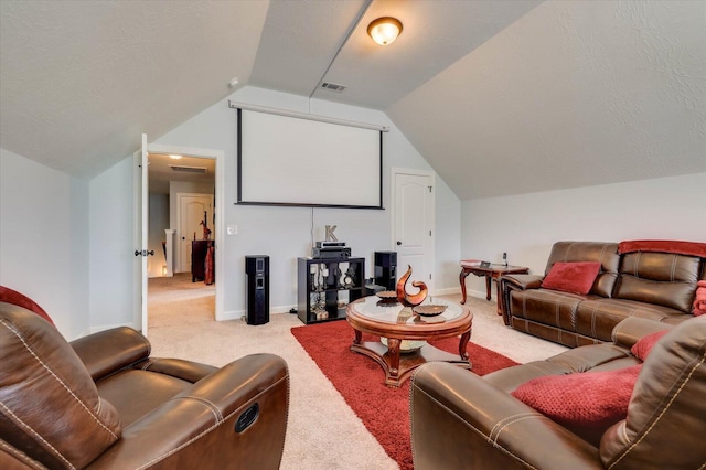 carpeted cinema room with lofted ceiling and a textured ceiling