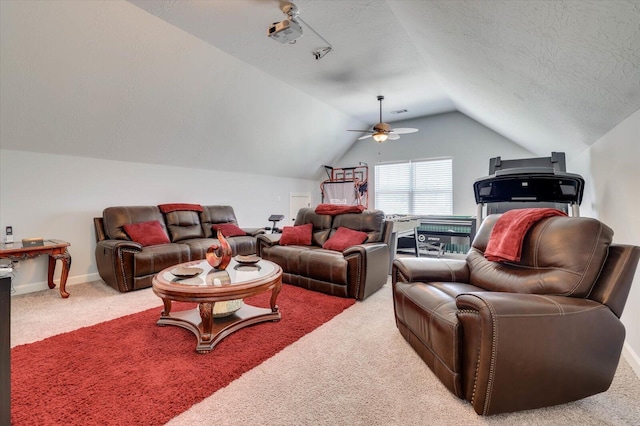 living room with carpet, ceiling fan, lofted ceiling, and a textured ceiling