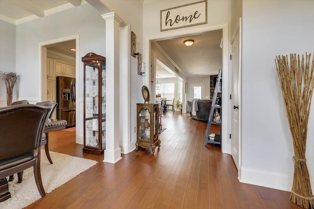 corridor with beam ceiling, ornate columns, dark hardwood / wood-style flooring, and ornamental molding