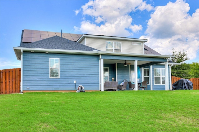 rear view of house featuring a lawn, ceiling fan, solar panels, an outdoor living space, and a patio area