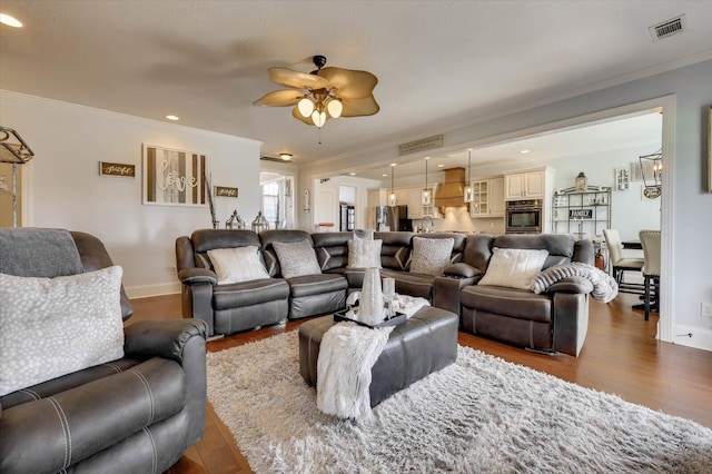 living room with ceiling fan, ornamental molding, and hardwood / wood-style flooring