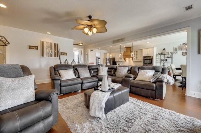 living room with ceiling fan, ornamental molding, and hardwood / wood-style flooring