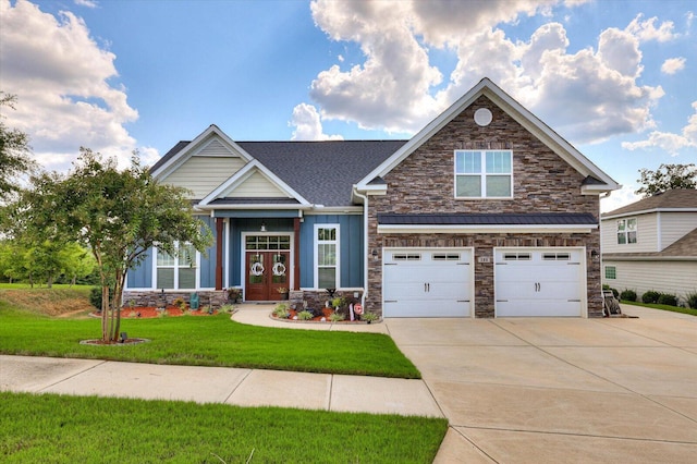 craftsman-style home featuring a garage, a front yard, and french doors