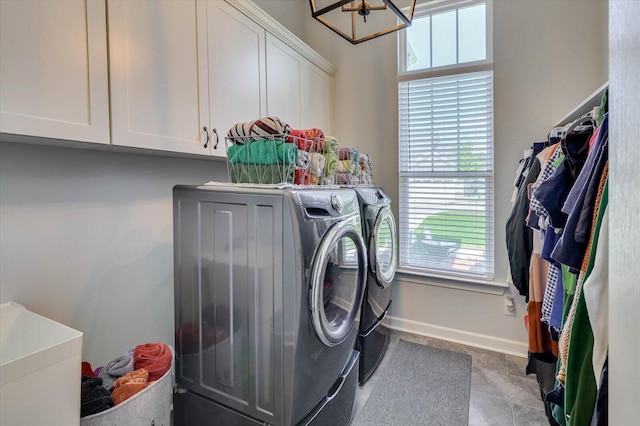 laundry room with cabinets, washing machine and dryer, sink, and a chandelier