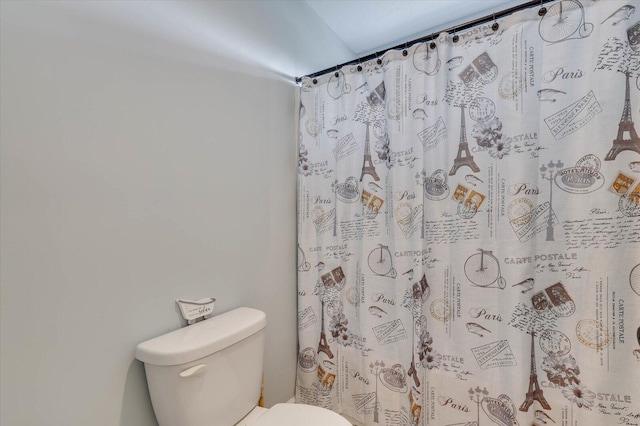 bathroom with a shower with curtain and toilet