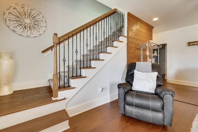 stairs featuring ornamental molding and hardwood / wood-style flooring