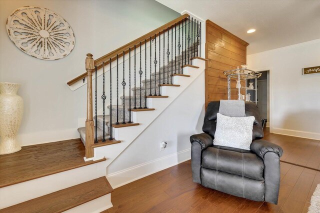 stairs featuring ornamental molding and hardwood / wood-style flooring