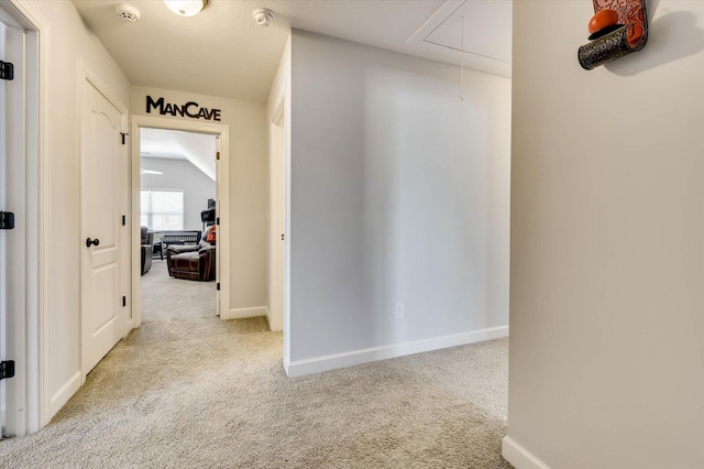 hallway featuring light carpet and vaulted ceiling