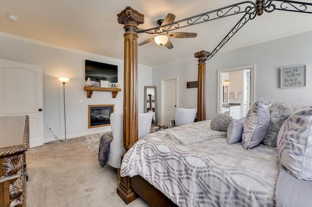 carpeted bedroom with ceiling fan, crown molding, and ensuite bath