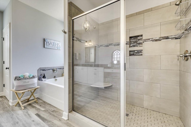 bathroom featuring hardwood / wood-style flooring and separate shower and tub