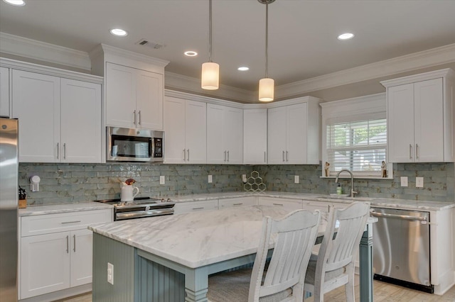 kitchen featuring a center island, white cabinets, stainless steel appliances, and sink