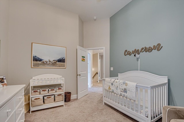 carpeted bedroom featuring a nursery area