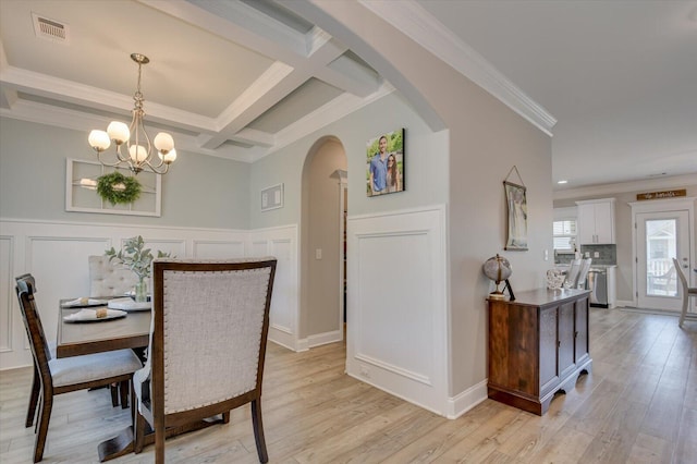 dining area with coffered ceiling, crown molding, light hardwood / wood-style flooring, a notable chandelier, and beamed ceiling