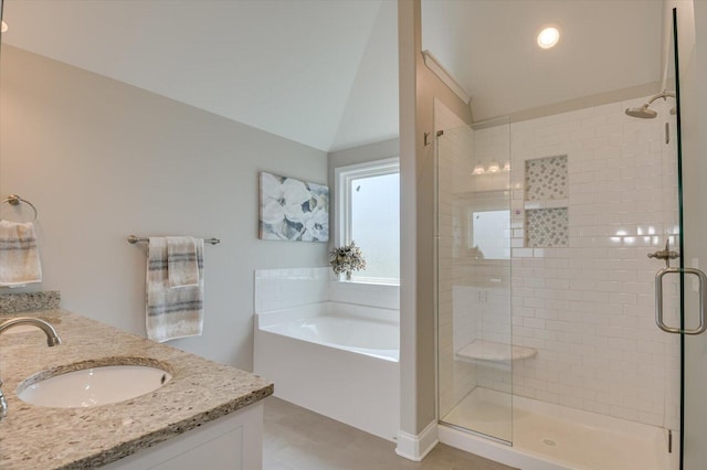 bathroom featuring vanity, vaulted ceiling, and independent shower and bath