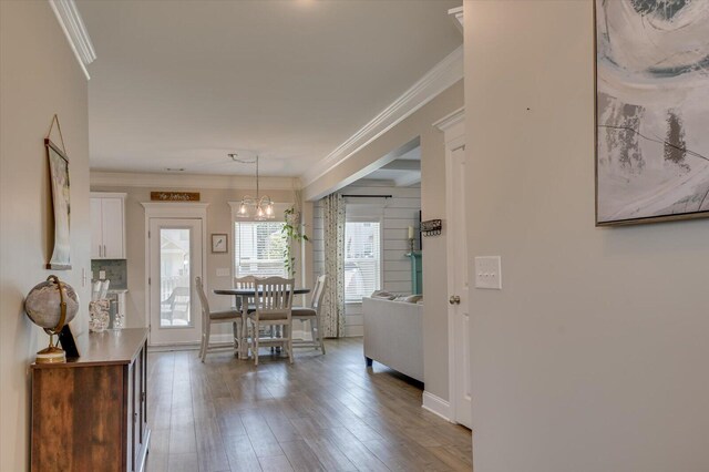 dining room with hardwood / wood-style flooring, an inviting chandelier, and crown molding