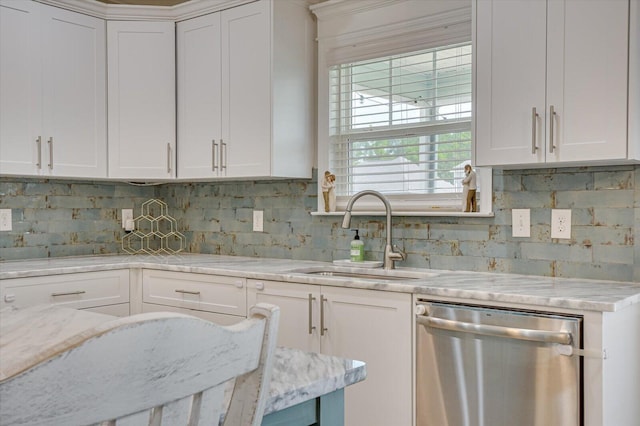 kitchen featuring backsplash, white cabinets, sink, stainless steel dishwasher, and light stone counters