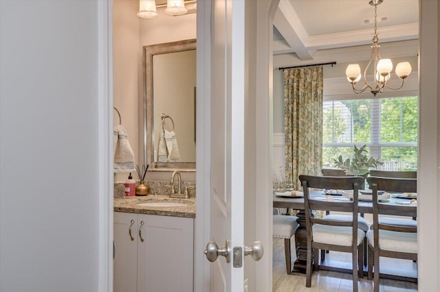 bathroom with coffered ceiling, vanity, beamed ceiling, and a chandelier