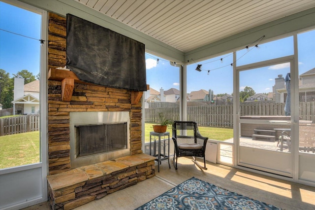 sunroom / solarium with an outdoor stone fireplace