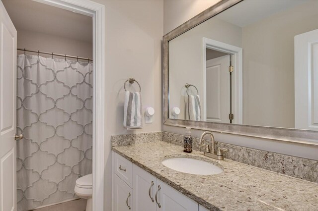 bathroom featuring a shower with shower curtain, vanity, and toilet