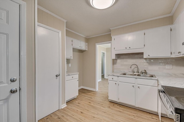 kitchen with a textured ceiling, white cabinetry, sink, ornamental molding, and light wood-type flooring