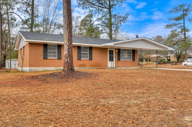 ranch-style home with a storage unit and a carport