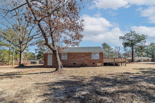 rear view of house with a wooden deck and a yard