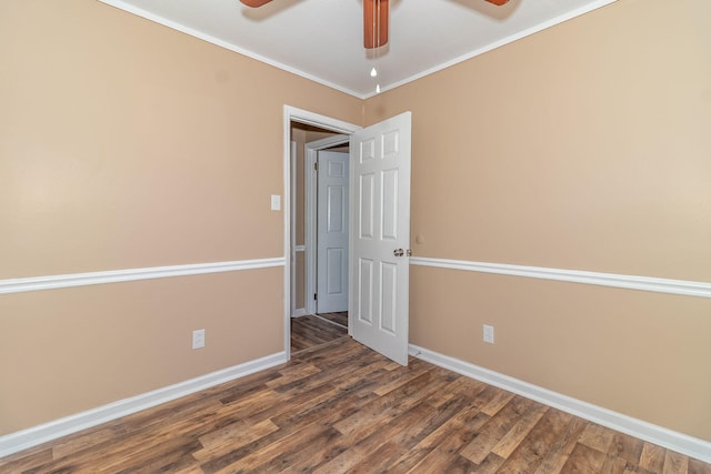 empty room featuring dark wood-type flooring, ceiling fan, and ornamental molding