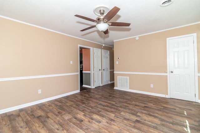 empty room with crown molding, ceiling fan, and dark hardwood / wood-style flooring