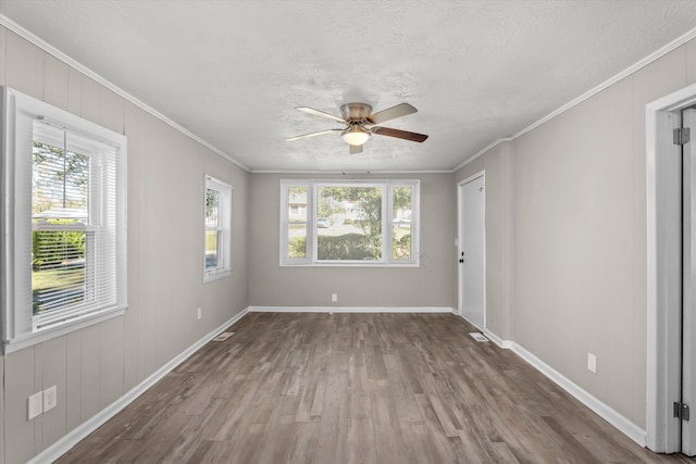 spare room featuring ceiling fan, wood-type flooring, a textured ceiling, and ornamental molding