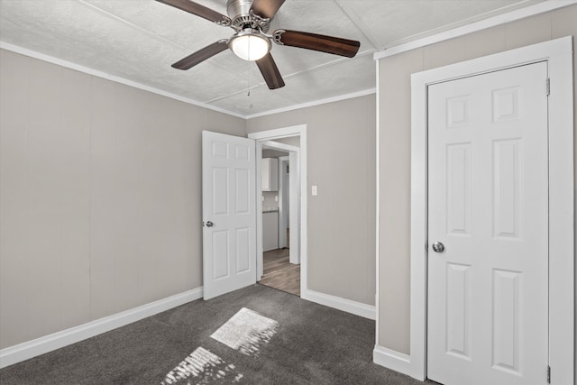 unfurnished bedroom with dark colored carpet, ceiling fan, and ornamental molding