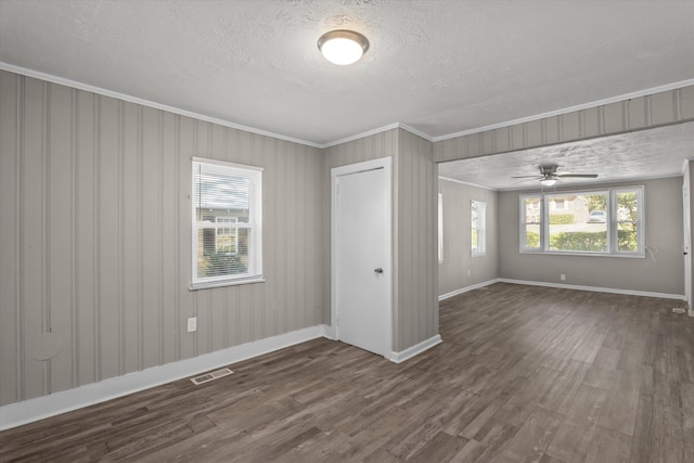 unfurnished bedroom with a closet, dark hardwood / wood-style flooring, ornamental molding, and multiple windows