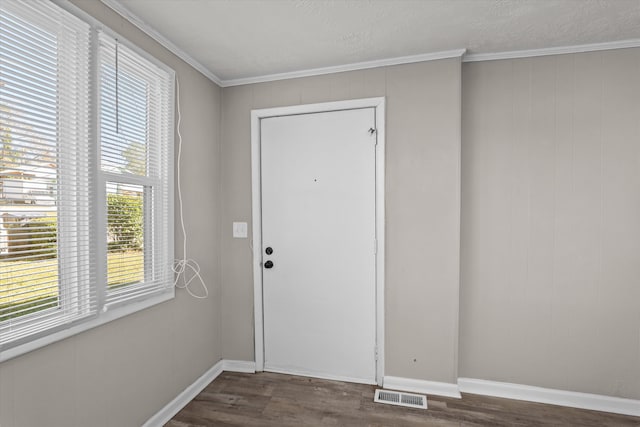 doorway to outside featuring dark hardwood / wood-style flooring, a textured ceiling, and ornamental molding