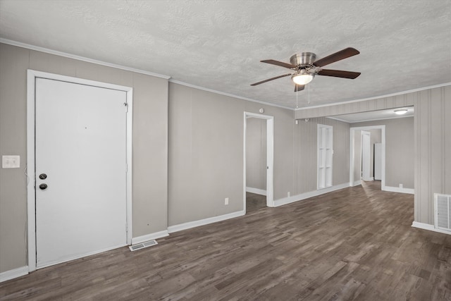 empty room featuring a textured ceiling, ceiling fan, dark hardwood / wood-style flooring, and crown molding