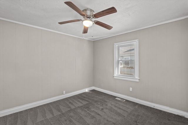 unfurnished room featuring dark colored carpet, ceiling fan, and crown molding