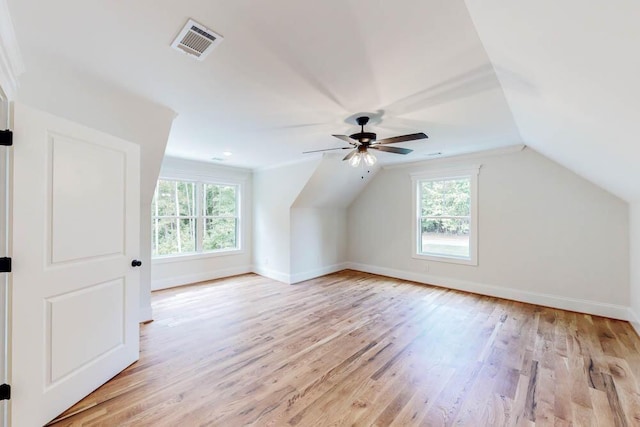 additional living space featuring vaulted ceiling, baseboards, visible vents, and light wood-style floors