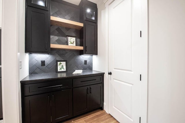 bar featuring light wood-style flooring and decorative backsplash