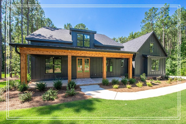 view of front of home featuring board and batten siding, a front yard, french doors, and a shingled roof