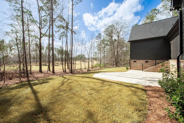 view of yard with a patio area and stairway